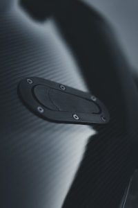 Artistic close-up of a carbon fiber vehicle surface showcasing texture and sleek design.